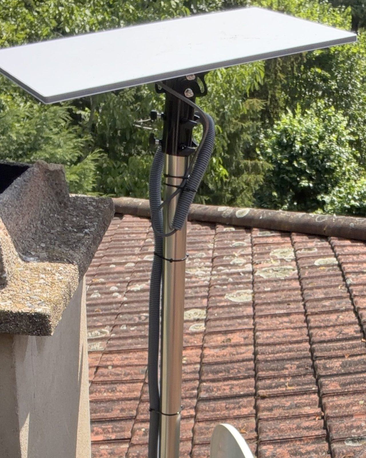 Antenne Starlink fixée sur un mât au-dessus d'une toiture à Lyon