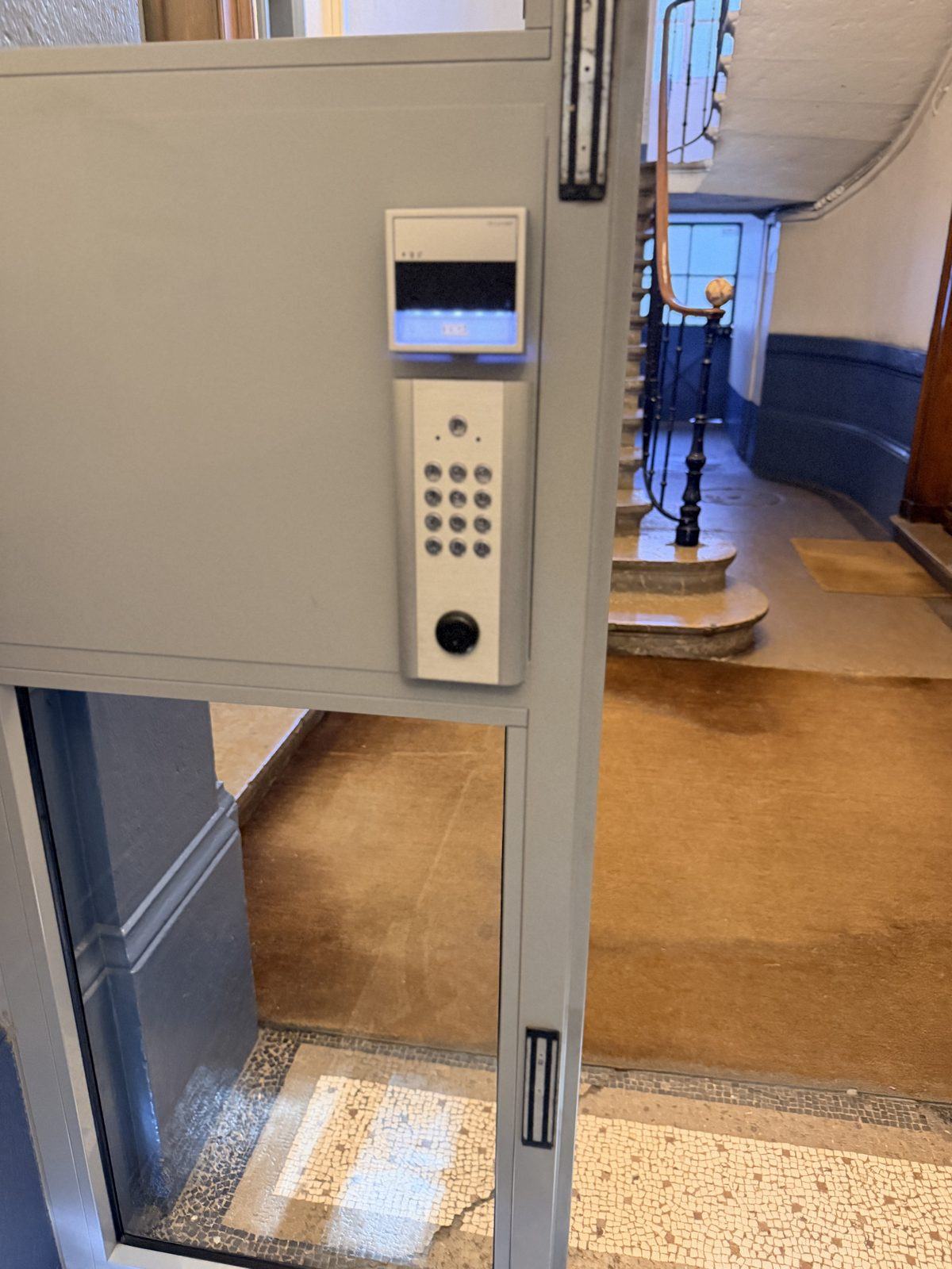 Platine à clavier et lecteur de badge dans un hall d'immeuble ancien à Lyon