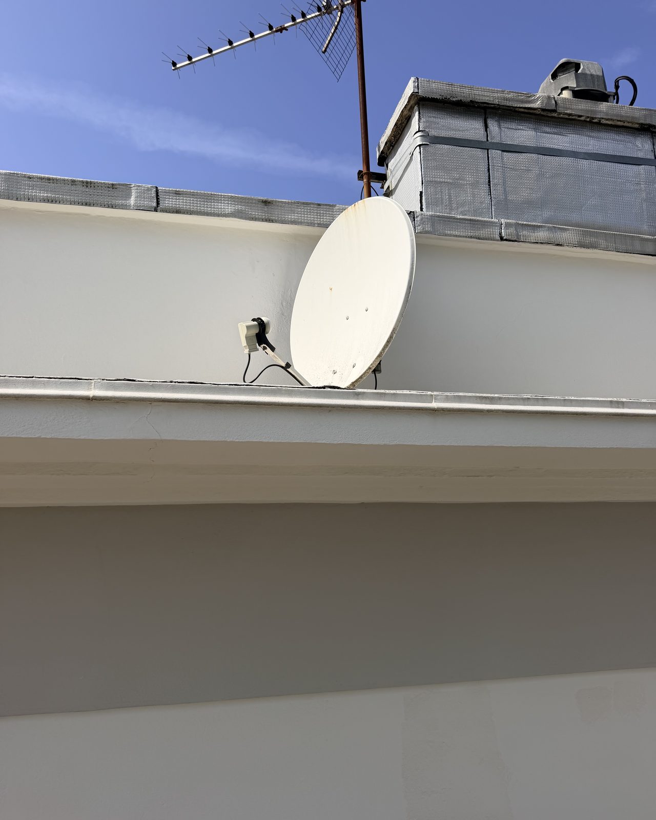 Parabole satellite et antenne TNT installées sur une terrasse à Lyon