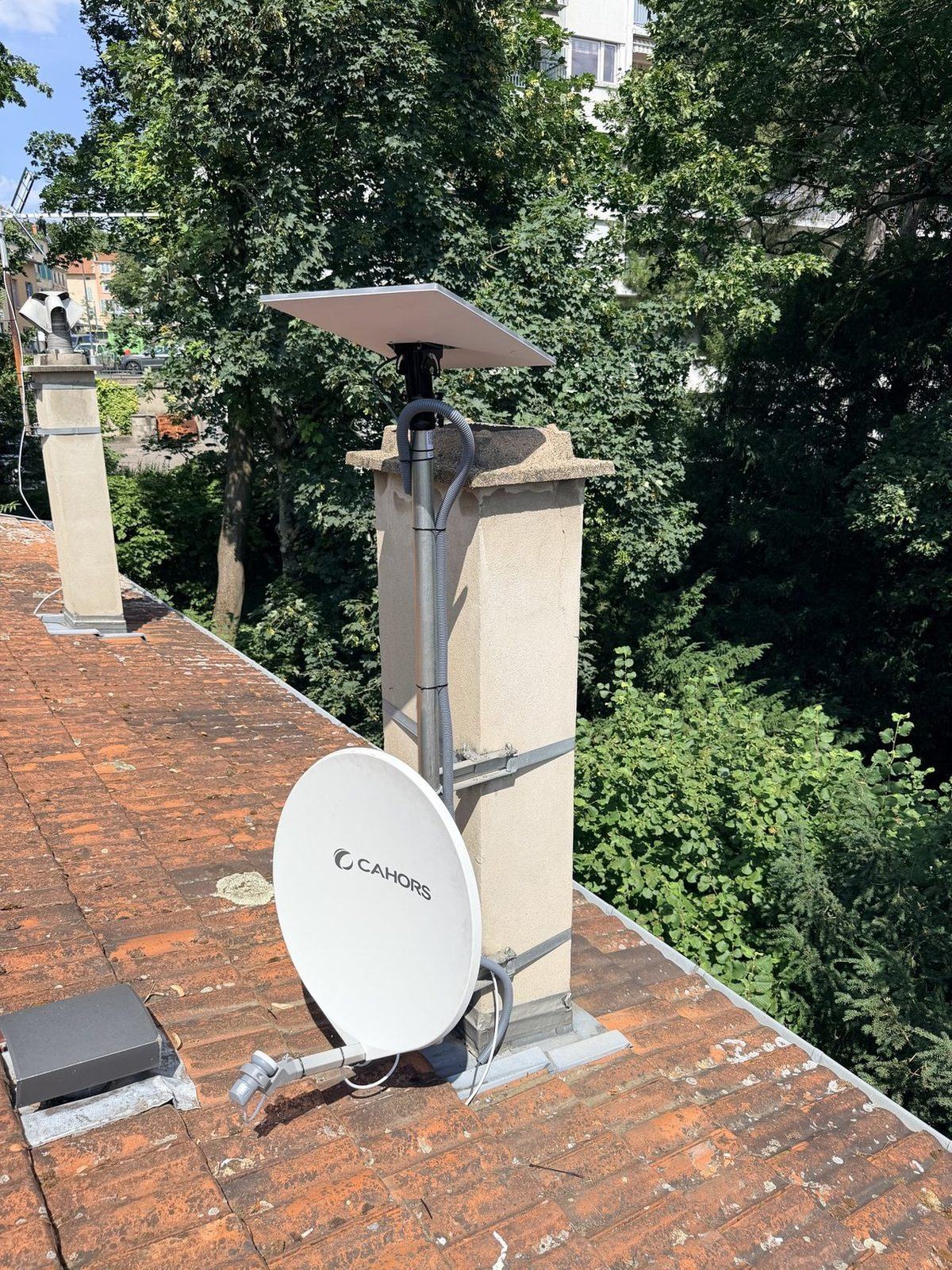 Kit Starlink et parabole satellite installés sur le même mât, sur une cheminée à Lyon