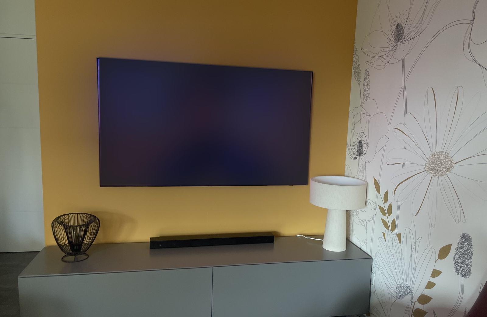 TV murale fixée au-dessus d'un meuble avec barre de son, installée par MKS Technology à Lyon